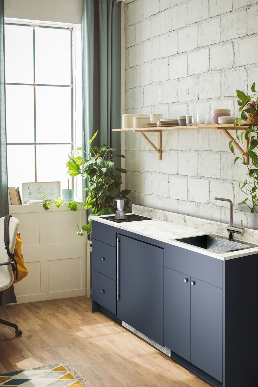 ADA-height Turnkey Caldera Kitchen featuring pre-assembled cabinetry and countertop in a modern midnight navy finish, complete with ENERGY STAR certified refrigerator-freezer, ENERGY STAR certified 115V induction cooktop, storage drawers, and sink with faucet; ships in two boxes on one pallet